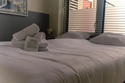 a white bed with towels and a sign on it at Amsterdam Beach Home 88 in Zandvoort