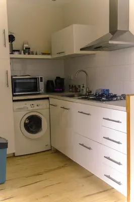 a kitchen with a washing machine and a microwave at Amsterdam Beach Home 88 in Zandvoort