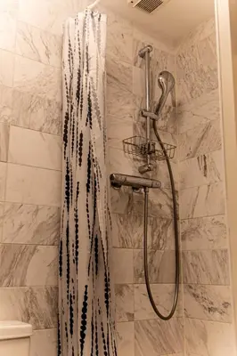 a shower with a black and white shower curtain in a bathroom at Amsterdam Beach Home 88 in Zandvoort