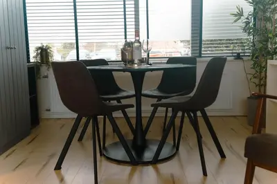 a black table and chairs in a room with windows at Amsterdam Beach Home 88 in Zandvoort
