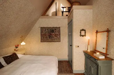a bedroom with a bed and a candle on a table at Atteheem in Breukelen