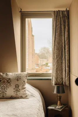 a bedroom with a window with a bed and a lamp at Atteheem in Breukelen