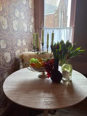 a table with a bowl of fruit and flowers on it at Atteheem in Breukelen