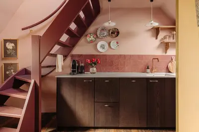 a kitchen with brown cabinets and a purple staircase at Atteheem in Breukelen