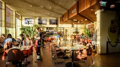 a group of people sitting at tables in a restaurant at Pension Homeland in Amsterdam