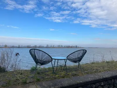 two chairs and a table in front of the water at Spacious house IJmeer Amsterdam - east IJburg in Amsterdam
