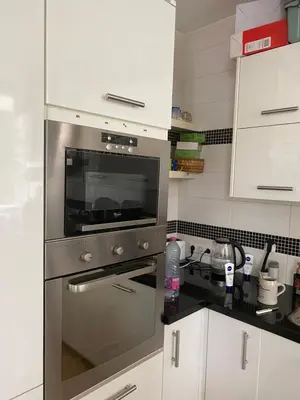 a kitchen with a stainless steel oven and white cabinets at Roses in Amstelveen