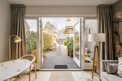 a living room with a door open to a patio at Green Heart Apartment Private Parking in Zandvoort