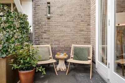 two chairs and a table on a patio at Green Heart Apartment Private Parking in Zandvoort