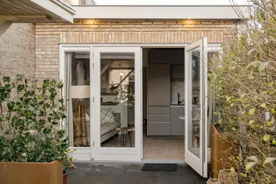 a glass extension to a house with a garden at Green Heart Apartment Private Parking in Zandvoort