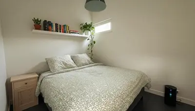a bedroom with a bed and a shelf with books at Natuurhuisje Abcoude - Groen Verblijf Buitenhuis in Abcoude