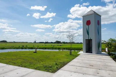 a monument with a flower painted on it next to a field at 10 persons Tulpenacker Comfort in Roelofarendsveen