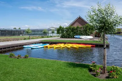 a bunch of kayaks are lined up on the water at 10 persons Tulpenacker Comfort in Roelofarendsveen