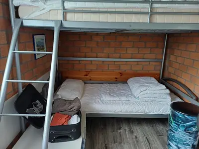 a room with a bunk bed and a brick wall at Ferienhaus Müller in Burgerbrug