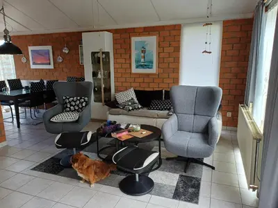 a living room with a couch and two chairs and a cat at Ferienhaus Müller in Burgerbrug