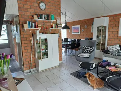 a kitchen and living room with a dog sitting on the floor at Ferienhaus Müller in Burgerbrug