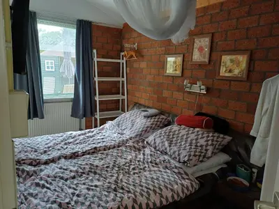a bedroom with a bed and a brick wall at Ferienhaus Müller in Burgerbrug
