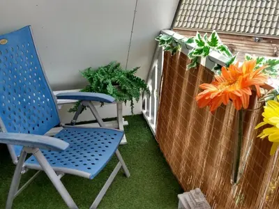 two blue chairs sitting on a balcony with plants at Cozy holiday home in Burgerbrug in Burgerbrug
