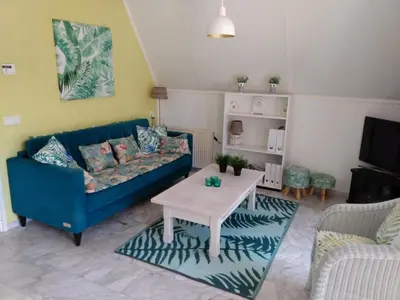 a living room with a blue couch and a table at Cozy holiday home in Burgerbrug in Burgerbrug