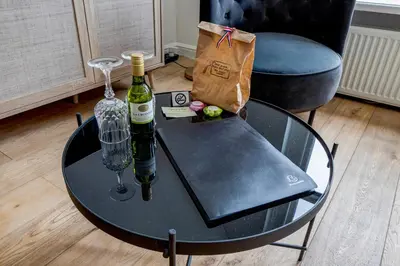 a glass table with a bottle of wine and a bag at Luxury Studio in Utrecht Center - view on canal in Utrecht
