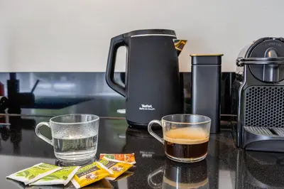 a coffee maker and two cups of tea on a counter at Luxury Studio in Utrecht Center - view on canal in Utrecht