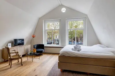 a bedroom with a bed and a large window at Luxury Studio in Utrecht Center - view on canal in Utrecht