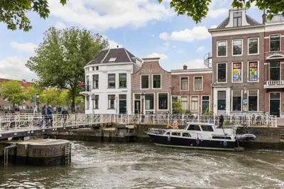 a boat in a river next to a bridge at Luxury Spacious Studio in Utrecht City Center in Utrecht
