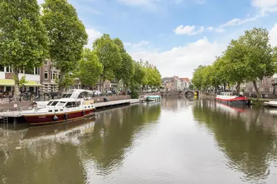 a boat is docked on a river in a city at Luxury Spacious Studio in Utrecht City Center in Utrecht
