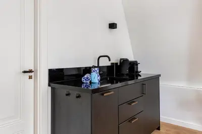 a kitchen with a black counter and a sink at 2 Luxurious Studios in Utrecht City Center in Utrecht