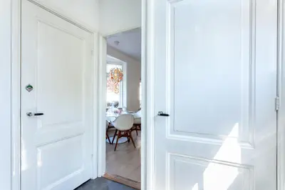 a white door leading into a dining room with a table at Casa Vos Family Home in Zandvoort