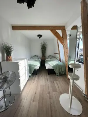 a room with two beds and a table in it at Casa Vos Family Home in Zandvoort