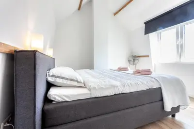 a bed in a bedroom with a large window at Casa Vos Family Home in Zandvoort