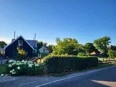a house with a bunch of flowers on the side of the road at B&B Koe en Kussen in Bodegraven