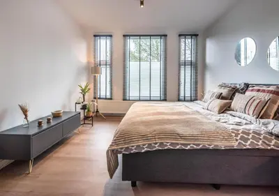a bedroom with a large bed and windows at Central Luxe Family Retreat in Amsterdam