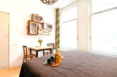 a room with a bed with a table and a window at AibarResidentieJH in Amsterdam