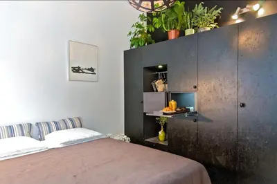 a bedroom with a bed and a cabinet with plants at AibarResidentieJH in Amsterdam