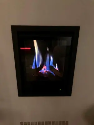 a television on a wall with a fire in it at OscarReestratResidence in Amsterdam