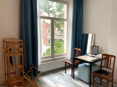 a room with a desk and a window with a table at OscarReestratResidence in Amsterdam