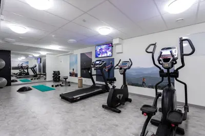 a gym with treadmills and exercise bikes in a room at Urban Lodge Hotel in Amsterdam