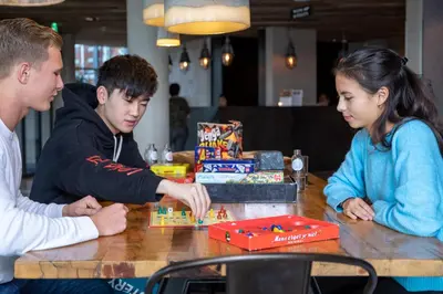 a group of people sitting around a table playing a game at Urban Lodge Hotel in Amsterdam