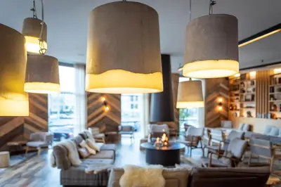 a lobby with couches and chairs and lights at Urban Lodge Hotel in Amsterdam