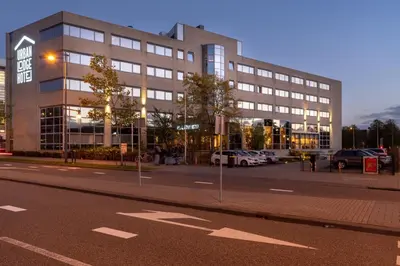 a large building with cars parked in front of it at Urban Lodge Hotel in Amsterdam