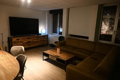 a living room with a couch and a flat screen tv at Dutchies Hostel in Amsterdam