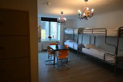 a room with two bunk beds and a table and chairs at Dutchies Hostel in Amsterdam