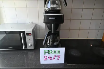 a coffee maker on a counter with a free sign at Dutchies Hostel in Amsterdam