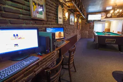 a room with a desk with a computer and a pool table at Travel Hotel Amsterdam in Amsterdam