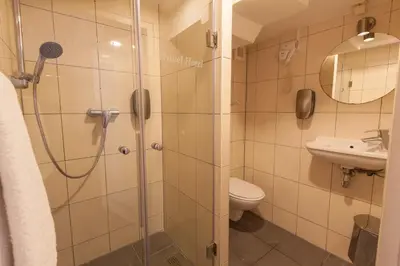 a bathroom with a shower and a toilet and a sink at Travel Hotel Amsterdam in Amsterdam