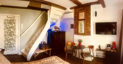 a room with a staircase and a table and chairs at Amsterdam Barangay in Amsterdam