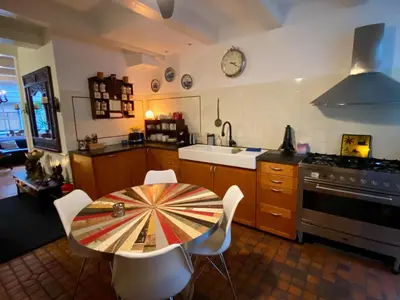 a kitchen with a table and chairs and a stove at Amsterdam Barangay in Amsterdam