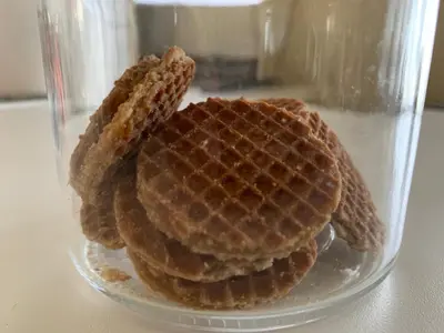 a glass container filled with waffle cookies on a table at Canal Studio Apartment in Amsterdam